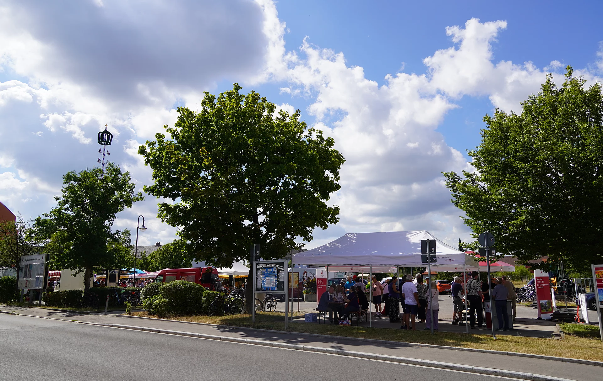 Sonnenschirme, Aufsteller und Bistrotische der Veranstaltung "Gespräche mit dem Stadtrat" am Königsbrunner Marktplatz. mit Aufsteller,