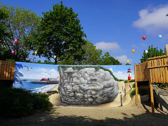 Spielplatz mit einer bemalte Kletterwand.